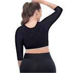 Black athletic crop top worn by a person on a white background