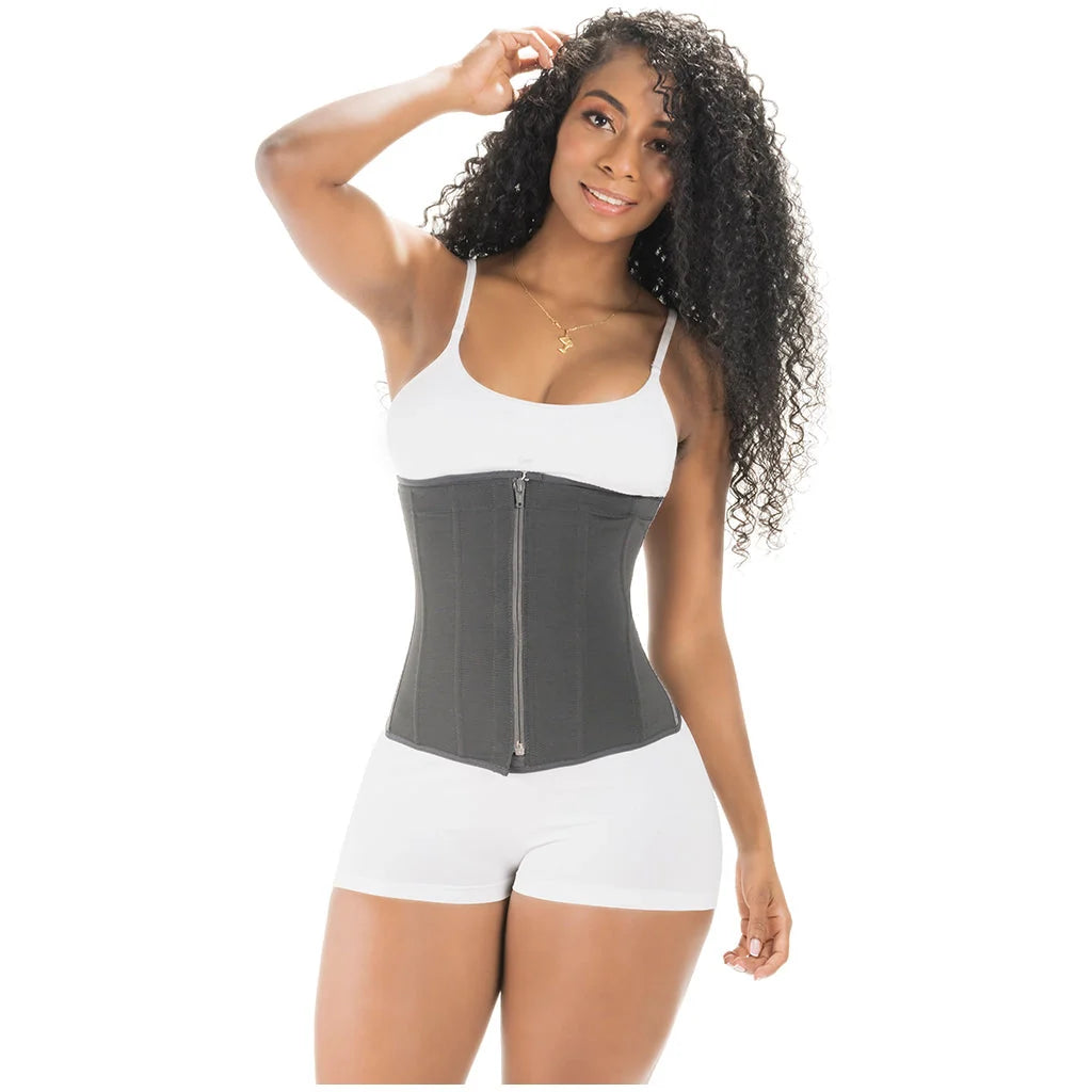 Woman wearing a gray waist trainer over a white tank top and shorts on a white background