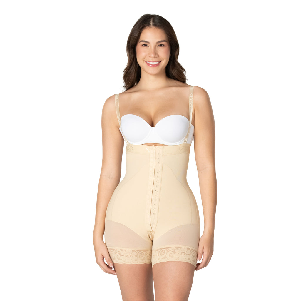 Woman wearing a beige shapewear body suit over a white bra on a white background
