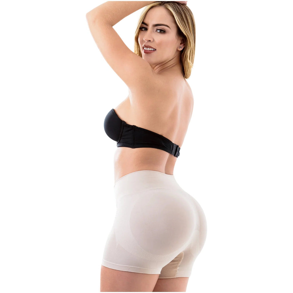 Woman wearing a black strapless top and beige shorts on a white background