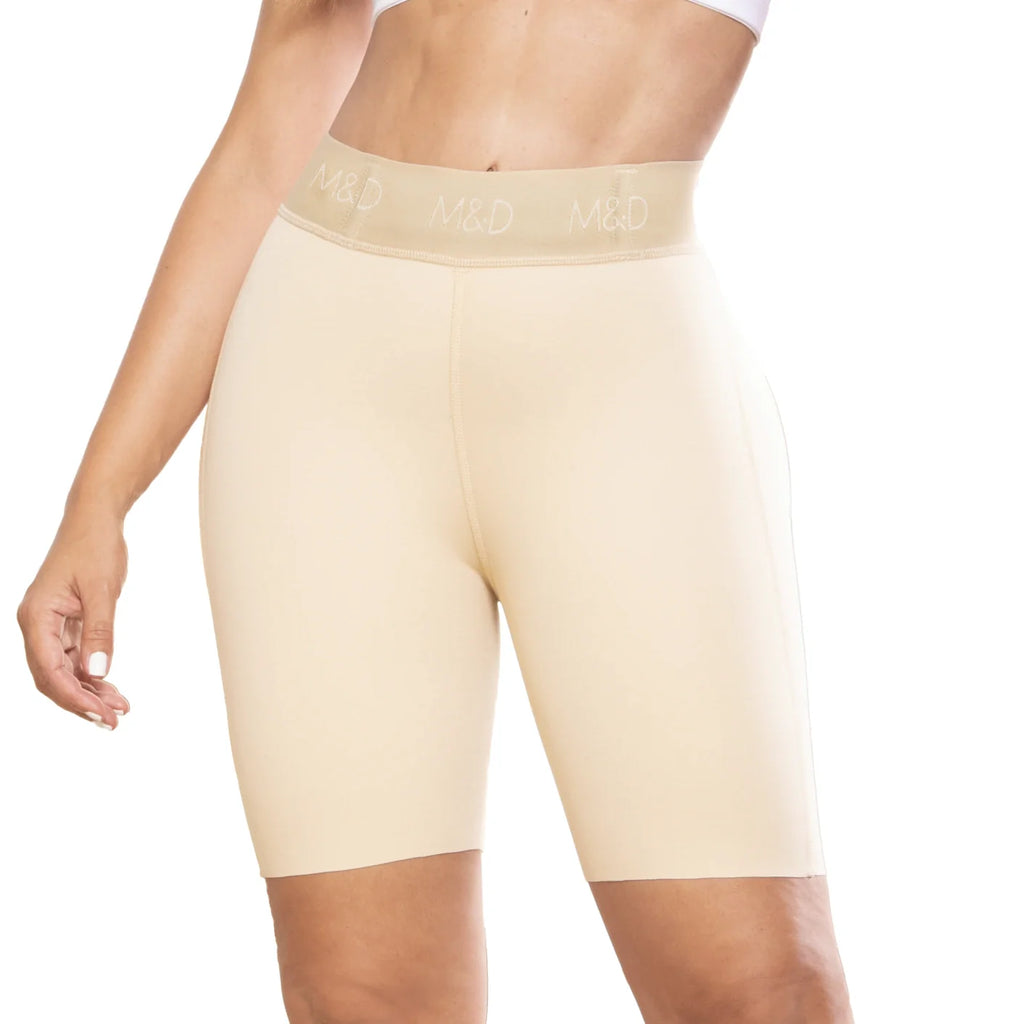 Beige compression shorts worn by a person on a white background