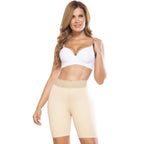 Woman wearing a white sports bra and beige shapewear on a white background