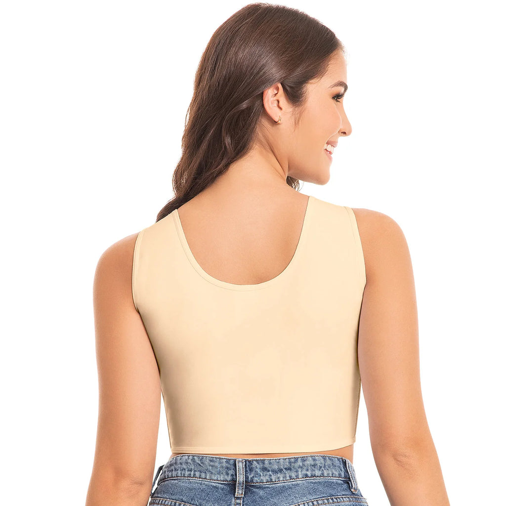Woman wearing a beige long bra and blue jeans on a white background