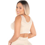 Woman wearing a beige sleeveless top on a white background