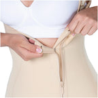 Person wearing a beige compression garment with a zipper, focusing on the waist area.