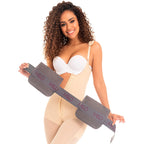 Woman wearing a beige body shaper with a visible waist trainer on a white background