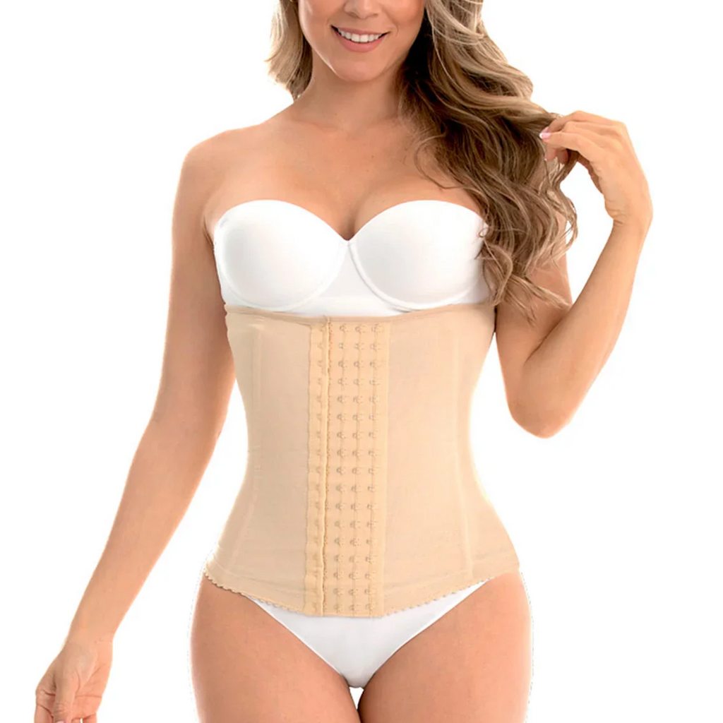 Woman wearing a beige waist trainer with a white strapless top on a white background