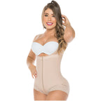 Woman wearing a beige shapewear bodysuit with a white bra on a white background