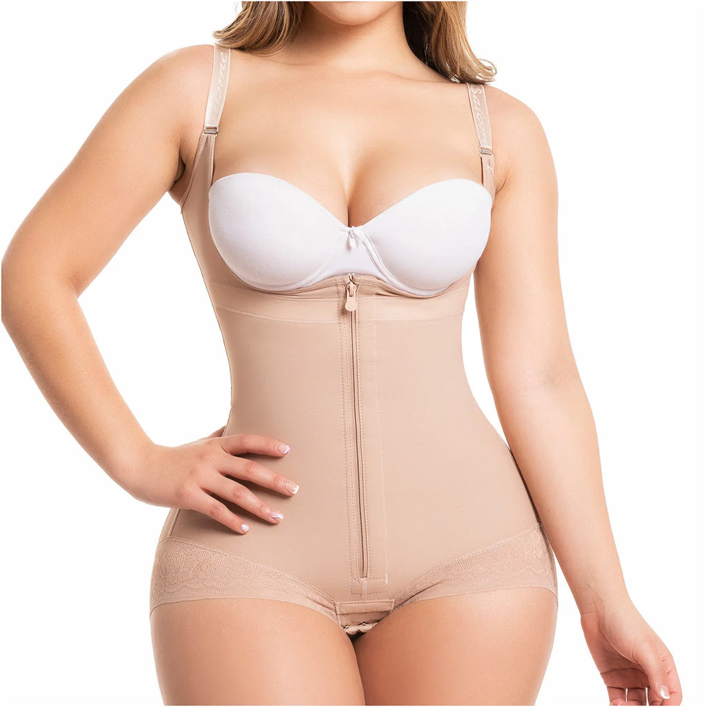Beige full-body shapewear with front zipper, open bust, and lace trim, worn with white bra, front view