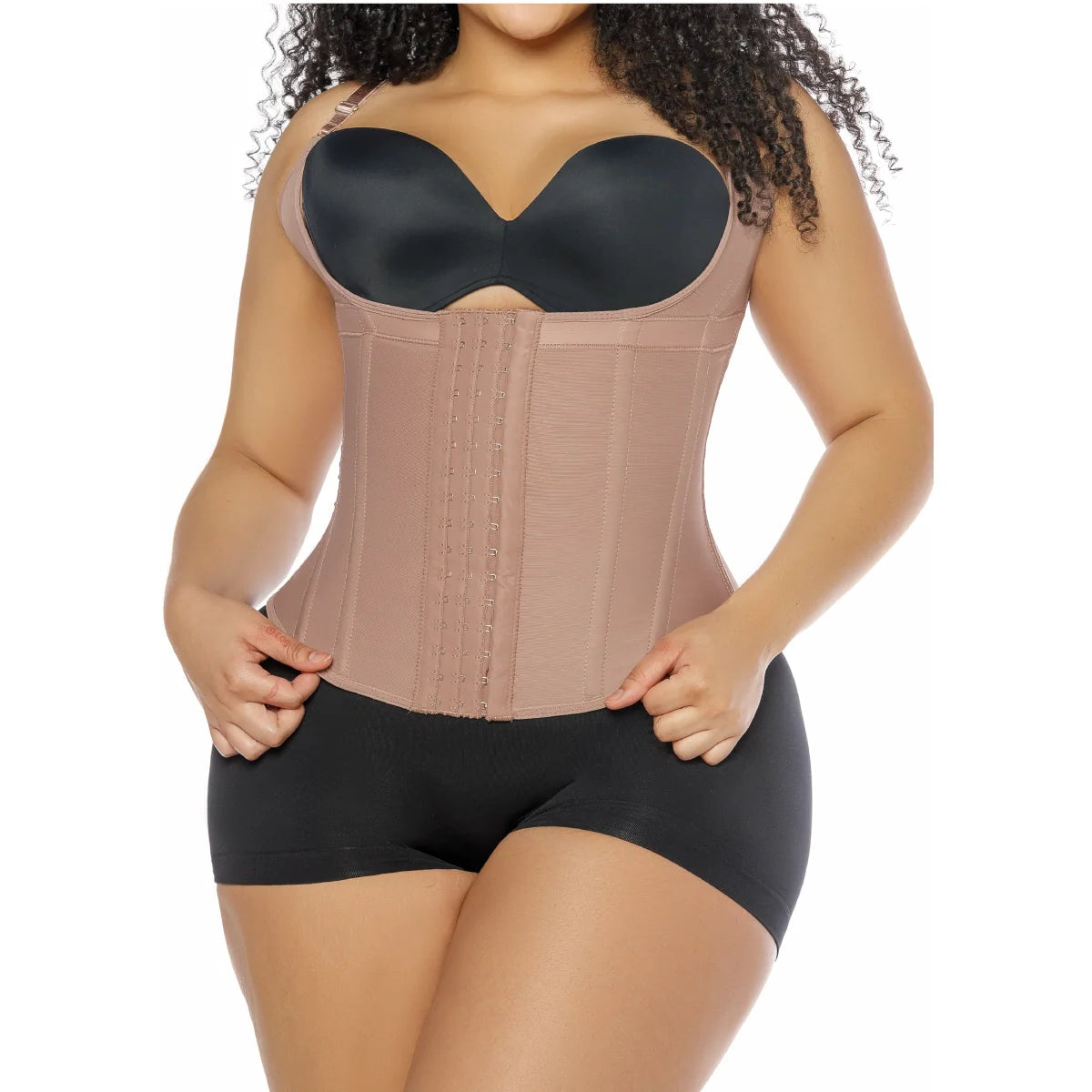 Woman wearing a beige waist trainer with a black bralette on a white background