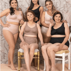 Group of women wearing lingerie posing together against a floral wallpaper background.