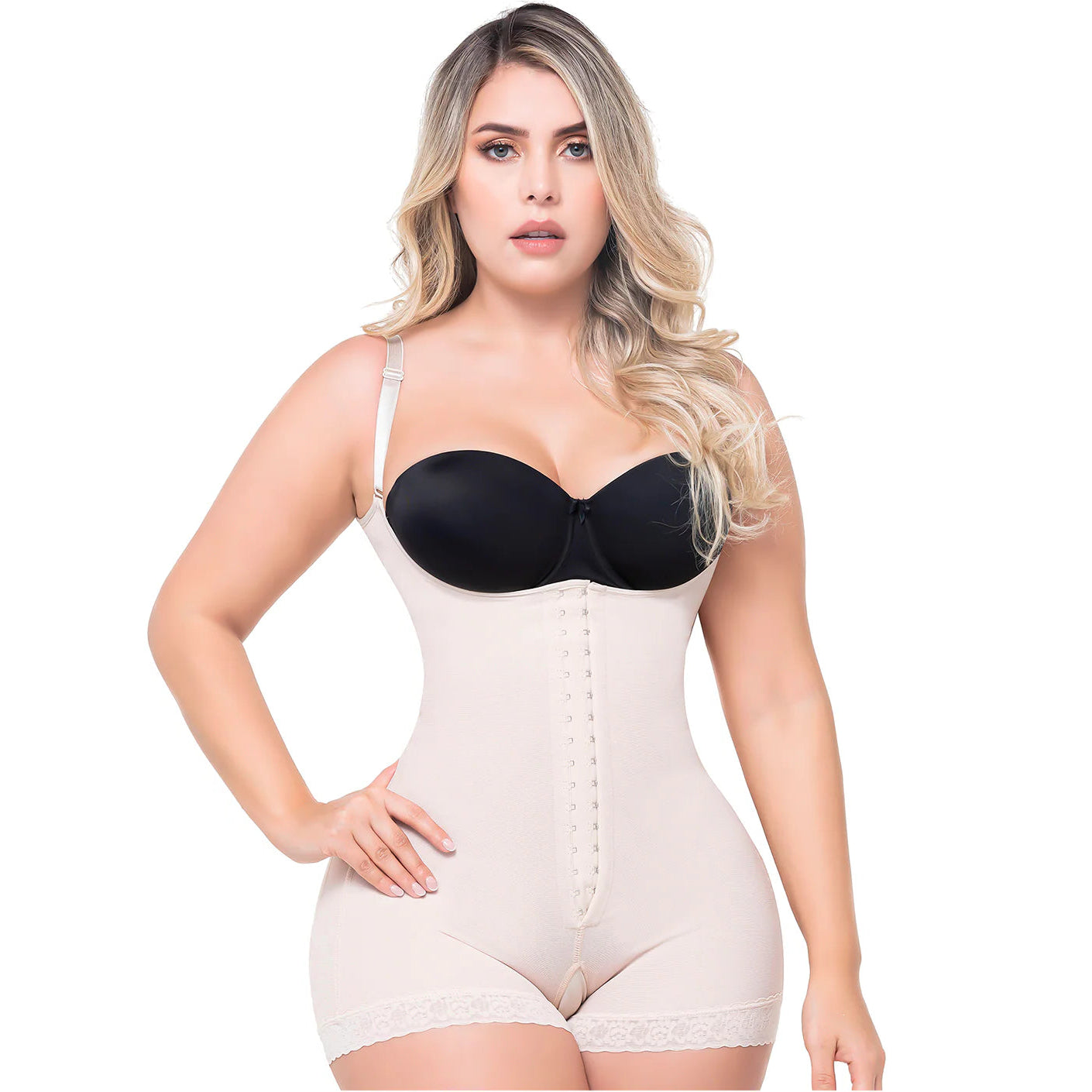 Woman wearing a black strapless top and beige body shaper on a white background
