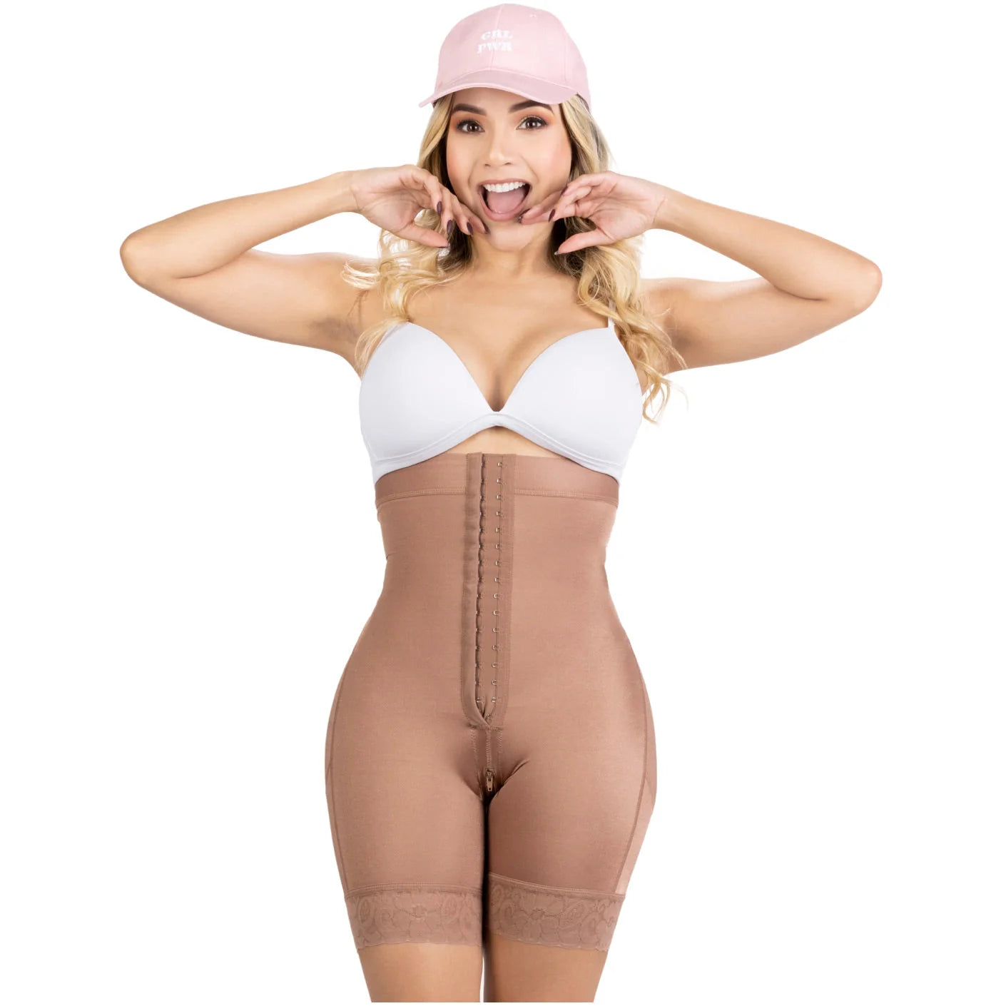 Woman wearing a beige shapewear garment and pink cap on a white background