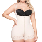 Woman wearing a black bra and beige shapewear on a white background