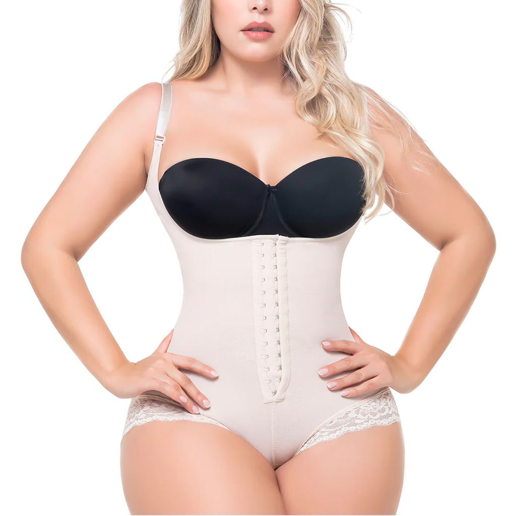 Woman wearing a black bra and beige body shaper on a white background