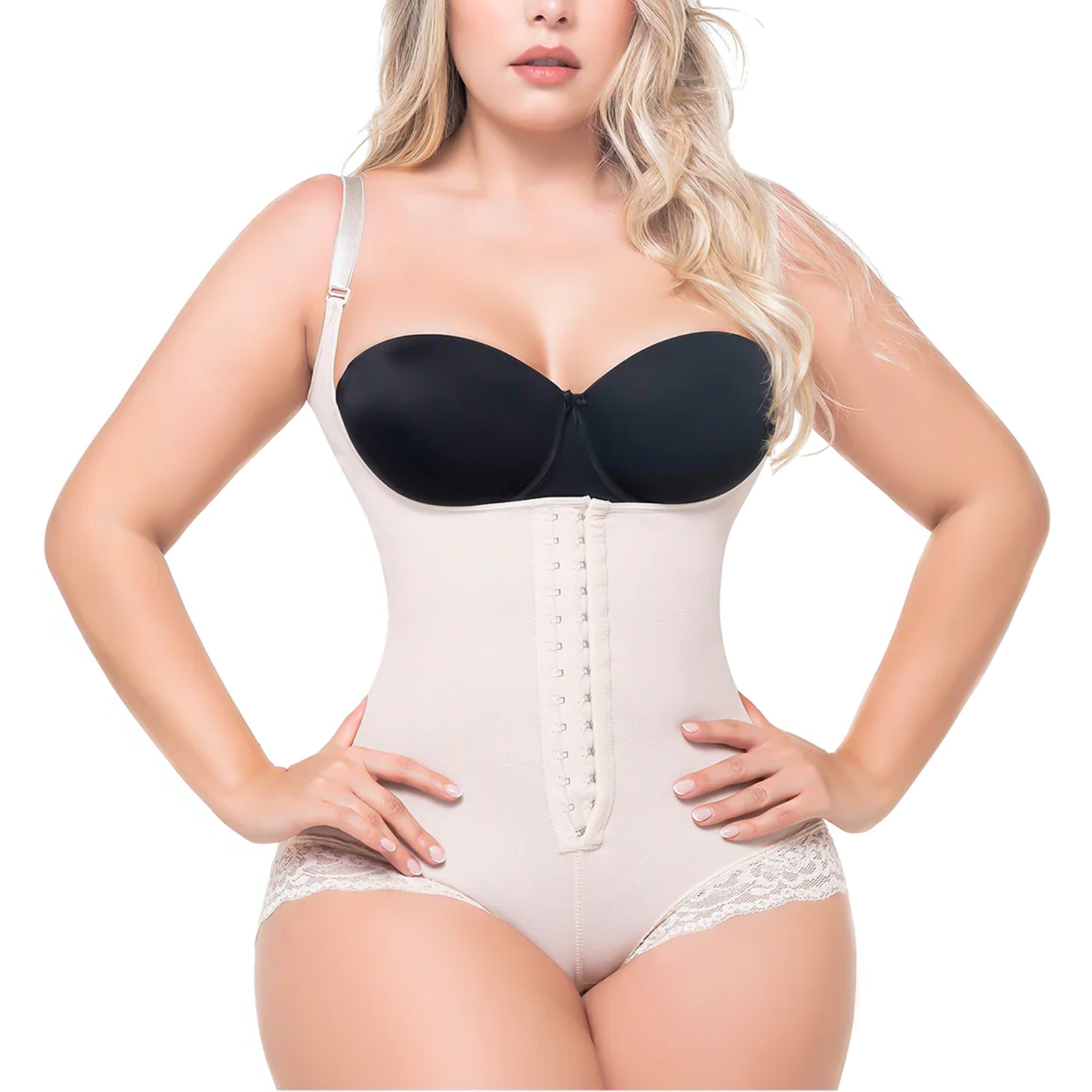 Woman wearing a black bra and beige body shaper on a white background