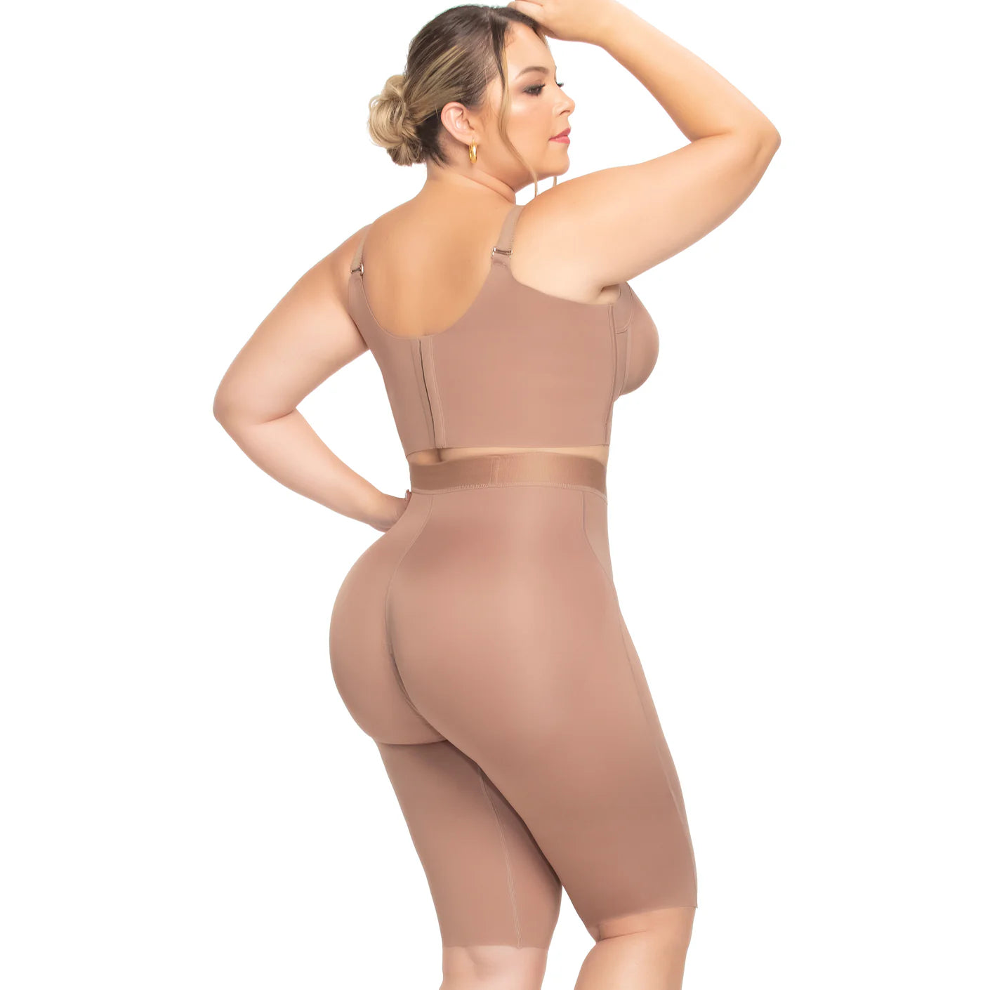 Woman wearing a beige shapewear bodysuit on a white background