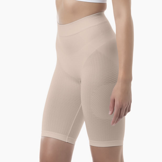 Beige shapewear shorts worn by a person on a white background