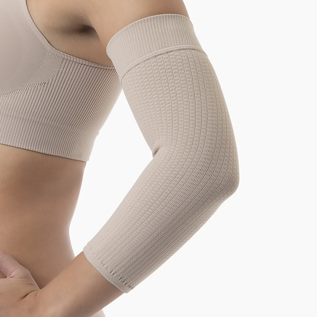 Beige compression sleeve on an arm against a white background