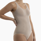 Beige bodysuit worn by a model on a white background
