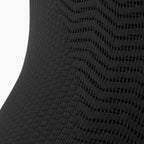 Close-up of a textured black fabric with a subtle pattern on a white background