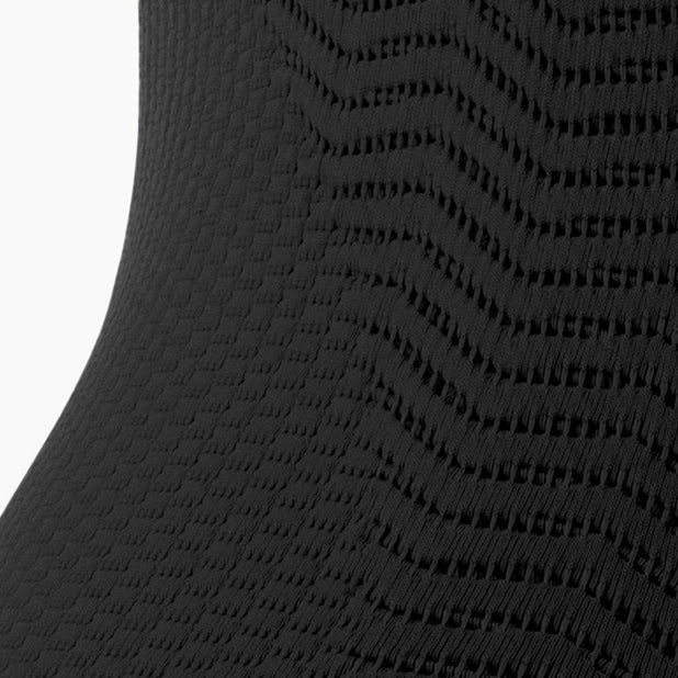 Close-up of a textured black fabric with a subtle pattern on a white background