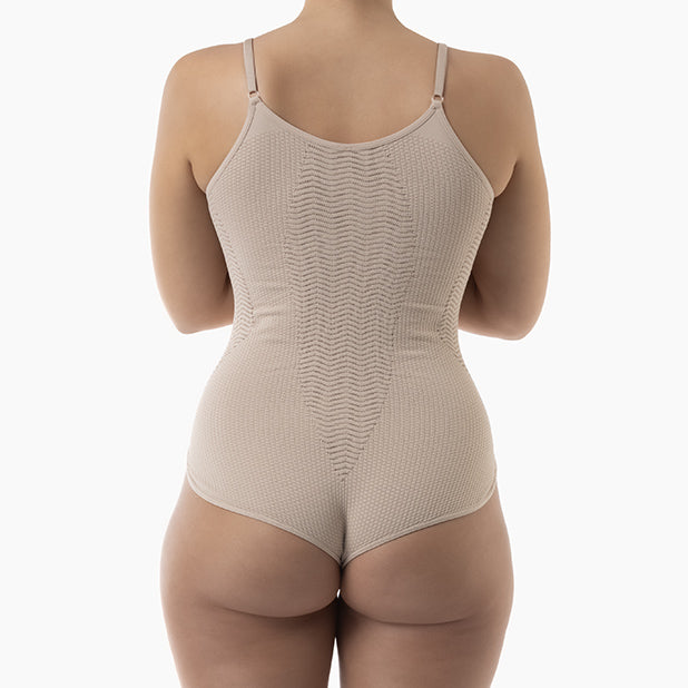 Beige bodysuit worn by a person on a white background