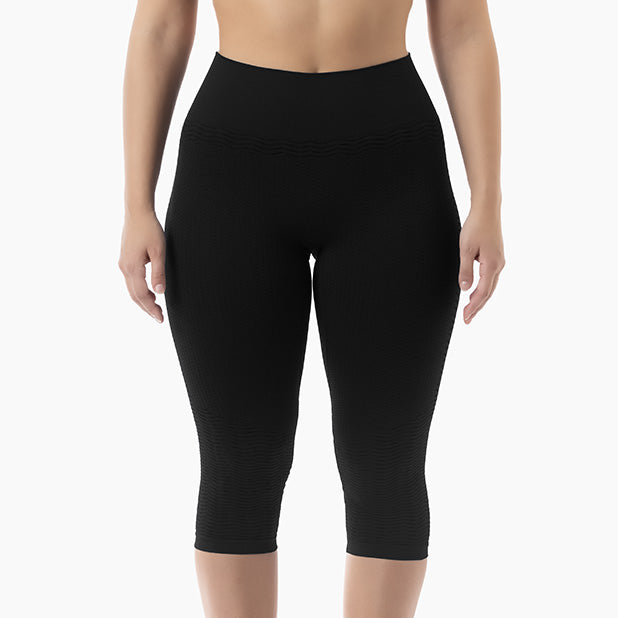 Black capri leggings worn by a person on a white background