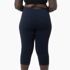 Navy blue capri leggings worn by a person on a white background