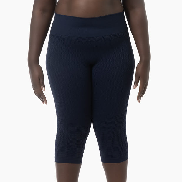 Person wearing navy blue leggings on a white background
