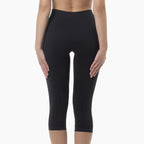 Black capri leggings worn by a person on a white background