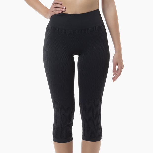 Black capri leggings worn by a person on a white background