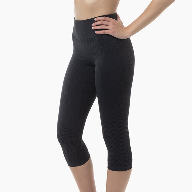 Black capri leggings worn by a person on a white background