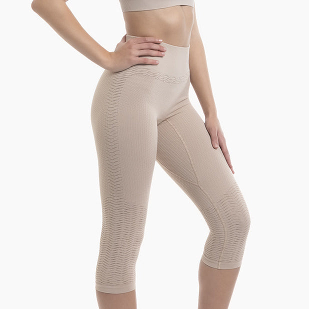 Beige compression leggings worn by a person on a white background