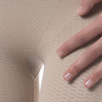 Close-up of a hand touching beige textured fabric