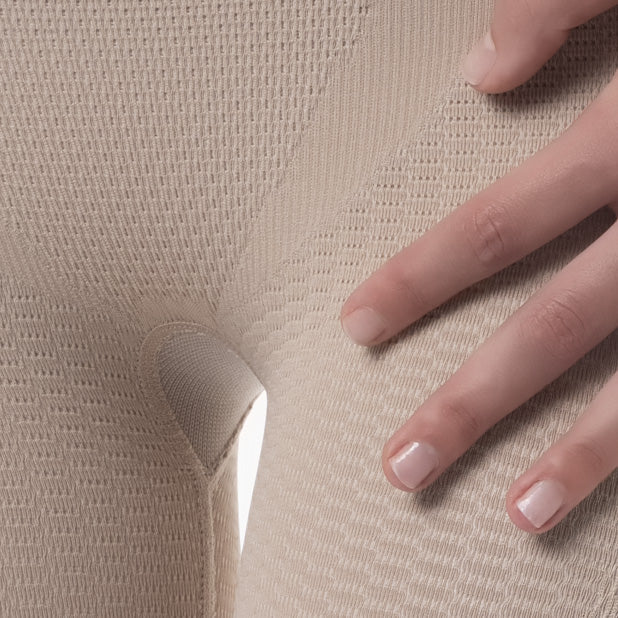 Close-up of a hand touching beige textured fabric