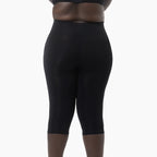 Black capri leggings worn by a person on a white background