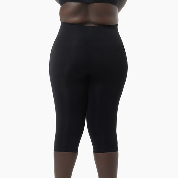 Black capri leggings worn by a person on a white background