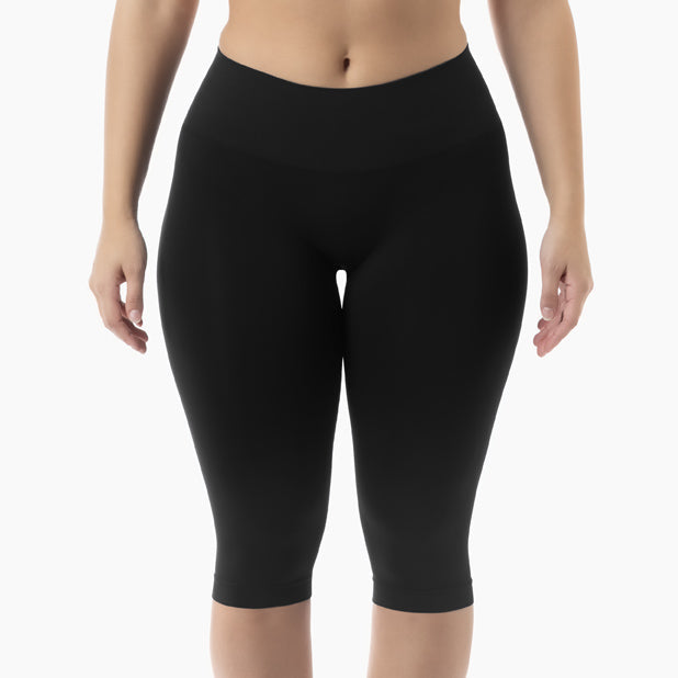 Black capri leggings worn by a person on a white background