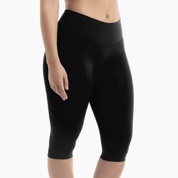 Black capri leggings worn by a person on a white background