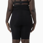 Person wearing a black outfit with sheer panels on a white background