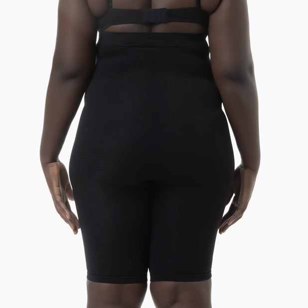 Person wearing a black outfit with sheer panels on a white background