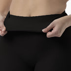 Person wearing black leggings with a close-up of the waistband.