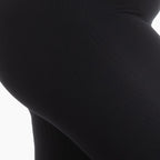 Close-up of black leggings on a white background