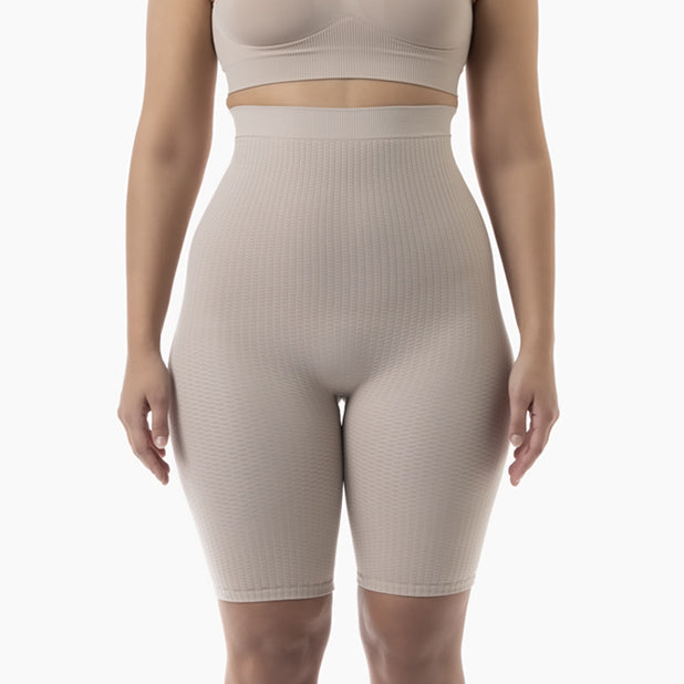 Beige ribbed high-waisted shorts worn by a person on a white background