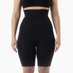 Black high-waisted shapewear shorts worn by a person on a white background
