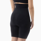 Black high-waisted shorts worn by a person on a white background