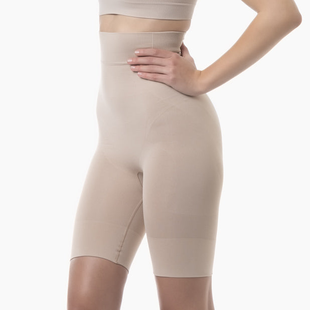Beige shapewear shorts worn by a person on a white background