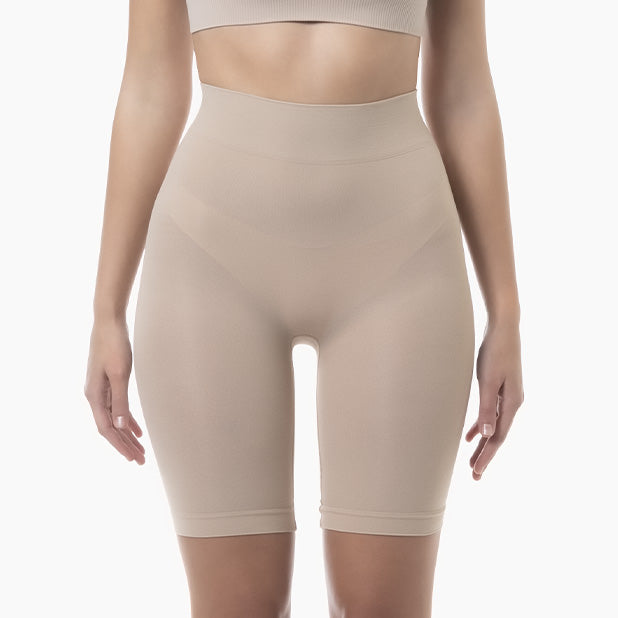 Beige shapewear shorts worn by a person on a white background