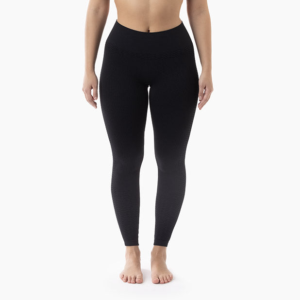 Person wearing black leggings on a white background